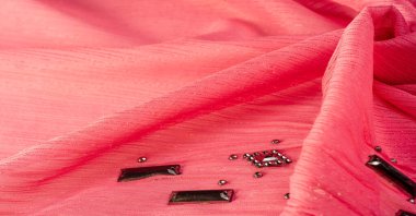 Arkaplan tasarımı dokusu, ipek desen, pembe kumaş ve dekoratif işlemeli taşlar.