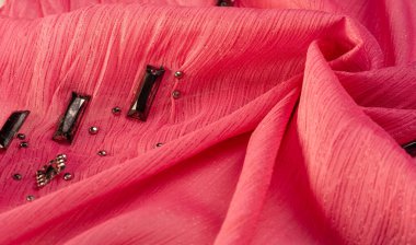 Arkaplan tasarımı dokusu, ipek desen, pembe kumaş ve dekoratif işlemeli taşlar.