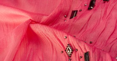 Arkaplan tasarımı dokusu, ipek desen, pembe kumaş ve dekoratif işlemeli taşlar.