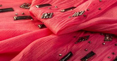 Arkaplan tasarımı dokusu, ipek desen, pembe kumaş ve dekoratif işlemeli taşlar.