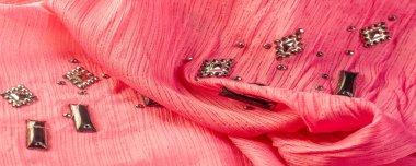 Arkaplan tasarımı dokusu, ipek desen, pembe kumaş ve dekoratif işlemeli taşlar.