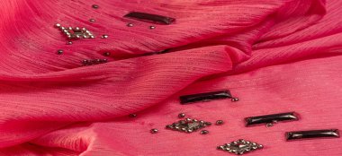 Arkaplan tasarımı dokusu, ipek desen, pembe kumaş ve dekoratif işlemeli taşlar.