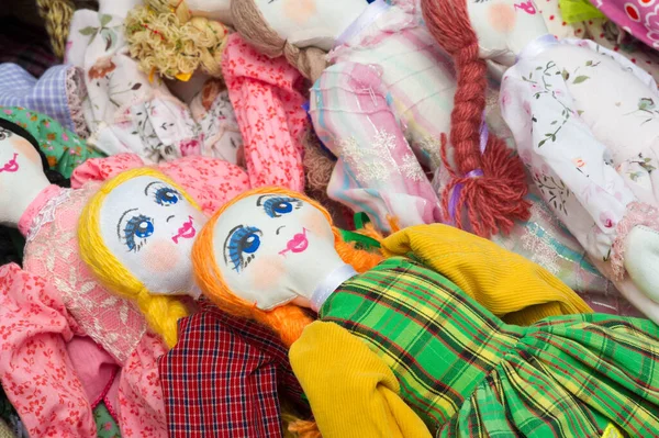 Flea market,  folk crafts. Handmade rag dolls. A rag doll is a children\'s toy. It is a cloth figure, a doll traditionally home-made from (and stuffed with) spare scraps of material.