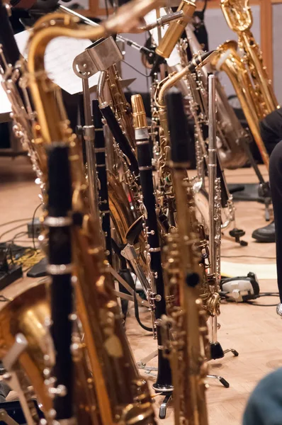 Large collection of woodwind instruments waiting for downbeat at a recording session
