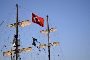 Tarihi bir korsan bir direk üzerinde çırpınan bir Türk bayrağı arka plan üzerinde mavi bir uzay gemisi. Türkiye