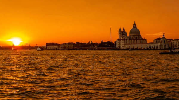 Venecia, Italia - 23 de octubre de 2018, una magnífica puesta de sol sobre el Gran Canal en el fondo de la Basílica de Santa Maria della Salute, en la ciudad de Venecia. El concepto de turismo y viajes — Foto de Stock