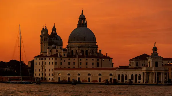 Venecia, Italia - 23 de octubre de 2018, una magnífica puesta de sol sobre el Gran Canal en el fondo de la Basílica de Santa Maria della Salute, en la ciudad de Venecia. El concepto de turismo y viajes — Foto de Stock