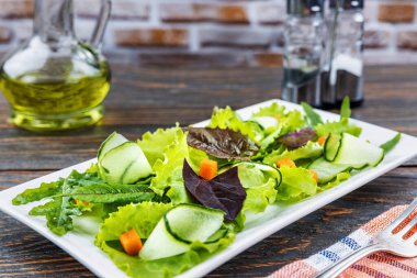 Eski ahşap bir masada ıspanak, roka, romantik havuçlu taze yeşil salata. Doğal sağlıklı gıda konsepti.