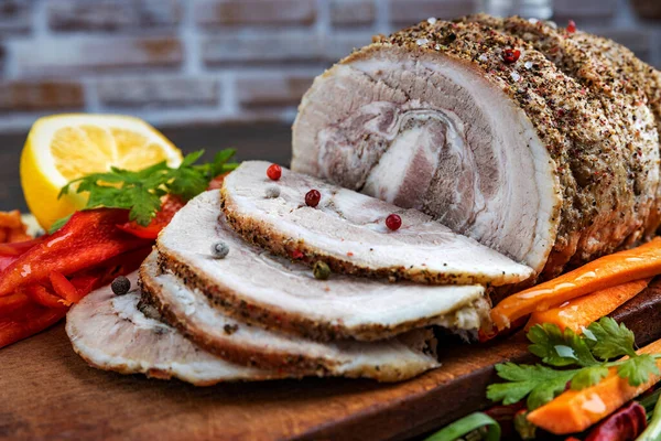 Cerdo horneado tradicional en rodajas adornado con hierbas, zanahorias de limón y especias, preparado para servir en la mesa festiva, primer plano, poca profundidad de campo, enfoque selectivo. El concepto de delicioso — Foto de Stock