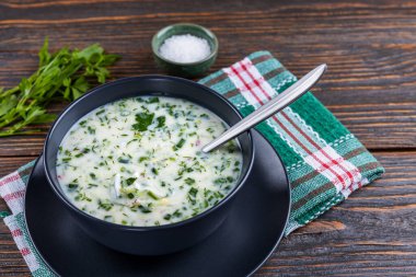 Taze salatalıklı soğuk çorba, ahşap arka planda yoğurtlu turp. Geleneksel Rus yemeği - okroshka. Vejetaryen yemeği. Sağlıklı yeme kavramı.