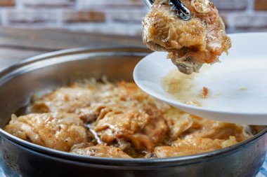 Tavuk butları tavada kızartılır ve tabakta tükürük ile servis edilir, yakın plan, yüzeysel alan derinliği, seçici odaklanma. Ev yapımı gıda konsepti.