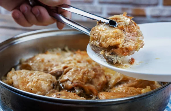 Los muslos de pollo se fríen en una sartén y se sirven con spitz en un plato, primer plano, profundidad de campo poco profunda, enfoque selectivo. Concepto de comida casera . — Foto de Stock