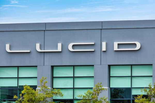 19 July 2025, Newark USA - Lucid Motors headquarters building in California USA with logo on facade and parked Lucid Air electric car in front, representing modern EV technology and innovative automotive design