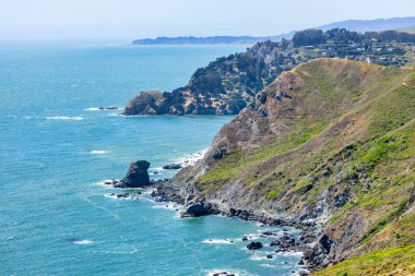 Scenic coastal cliffs along Tennessee Valley Trail in Marin Headlands, California. View of rugged shoreline, Pacific Ocean waves, and hillside trails leading toward the hidden Tennessee Beach