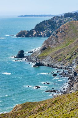 Scenic coastal cliffs along Tennessee Valley Trail in Marin Headlands, California. View of rugged shoreline, Pacific Ocean waves, and hillside trails leading toward the hidden Tennessee Beach