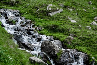 Dağ nehir yeşil çim ve Romanya, Transfagarasan taşlar arasında bir şelale