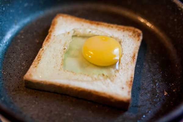 Tasty fried egg in a hole of a slice of bread for breakfast in a frying pan