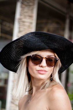 Elegance şık gülümseyen ve şapka ve güneş gözlüğü yürüyüş sokak ve kamera, duygular poz gülen genç kadın moda portre