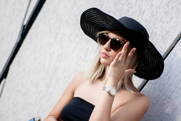 Elegance şık gülümseyen ve şapka ve güneş gözlüğü yürüyüş sokak ve kamera, duygular poz gülen genç kadın moda portre