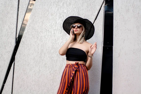 スタイリッシュな美しいの若い女性の帽子とメガネのスマート フォンを使用して屋外の Selfie を作る — ストック写真