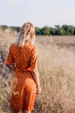 Eğleniyor ve sahada günbatımında poz neşeli güzel genç kadın
