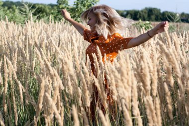 Eğleniyor ve sahada günbatımında poz neşeli güzel genç kadın