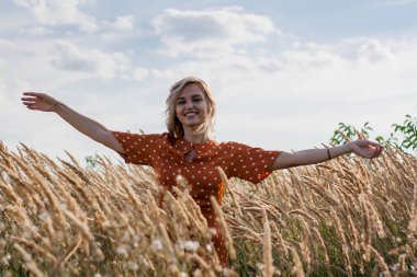 Eğleniyor ve sahada günbatımında poz neşeli güzel genç kadın