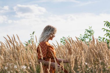 Eğleniyor ve sahada günbatımında poz neşeli güzel genç kadın