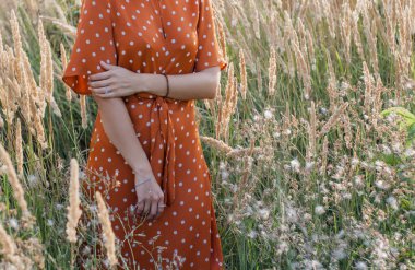 Eğleniyor ve sahada günbatımında poz neşeli güzel genç kadın