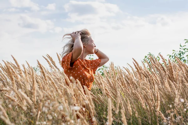 Eğleniyor ve sahada günbatımında poz neşeli güzel genç kadın
