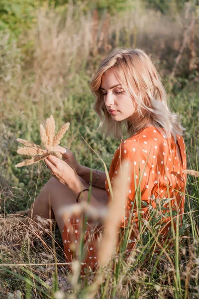 Güzel genç kadın alan toplar bir buket çiçek ve spikelets yürür, sunset Bulvarında bir çelenk çiçek örgüleri