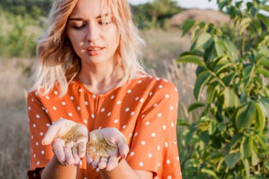 Genç Sarışın kadın alanında altın pırıltılar elleriyle günbatımı üzerinde seyir