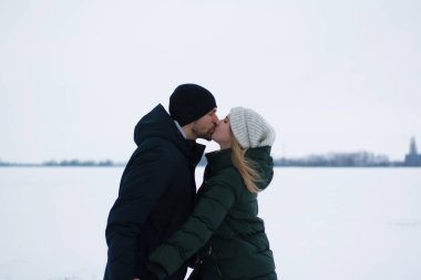 Genç Romantik Çift açık havada Noel öncesi kışın eğleniyor. Yeni yıl arifesi içinde birlikte vakit zevk. İki sevgili sarılma ve öpüşme Saint Valentine's Day.