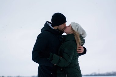 Genç Romantik Çift açık havada Noel öncesi kışın eğleniyor. Yeni yıl arifesi içinde birlikte vakit zevk. İki sevgili sarılma ve öpüşme Saint Valentine's Day.