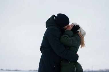 Genç Romantik Çift açık havada Noel öncesi kışın eğleniyor. Yeni yıl arifesi içinde birlikte vakit zevk. İki sevgili sarılma ve öpüşme Saint Valentine's Day.