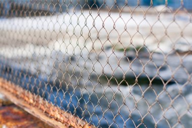 Arka planda, sahilde izole demir tel net