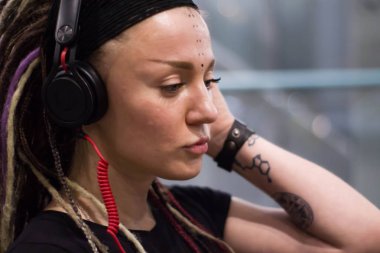 müzik ve havaalanında gece dans Kulaklığımda dreadlocks ile genç bir kadın. Eğleniyor