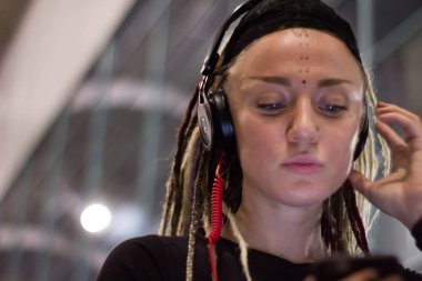 müzik ve havaalanında gece dans Kulaklığımda dreadlocks ile genç bir kadın. Eğleniyor