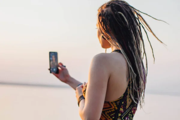 Joven Hermosa Hippie Mujer Con Rastas Utiliza Teléfono Inteligente Toma —  Fotos de Stock