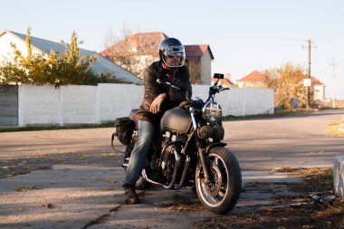 Adam ve gün batımında orman eski özel Cafe-racer motosiklet