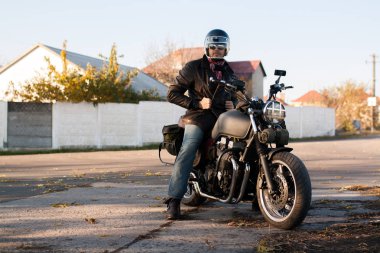 Adam ve gün batımında orman eski özel Cafe-racer motosiklet