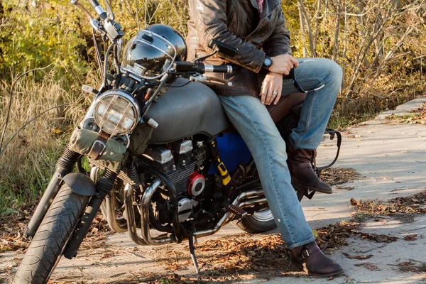 Adam ve gün batımında orman eski özel Cafe-racer motosiklet