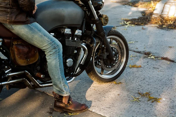 Adam ve gün batımında orman eski özel Cafe-racer motosiklet