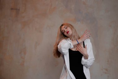 Loft studio arka plan üzerinde siyah tek parça streç giysi ve beyaz gömlek giymiş güzel ince genç kadın modern caz çağdaş bir tarz Bale dansçısı