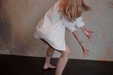 Loft studio arka plan üzerinde siyah tek parça streç giysi ve beyaz gömlek giymiş güzel ince genç kadın modern caz çağdaş bir tarz Bale dansçısı