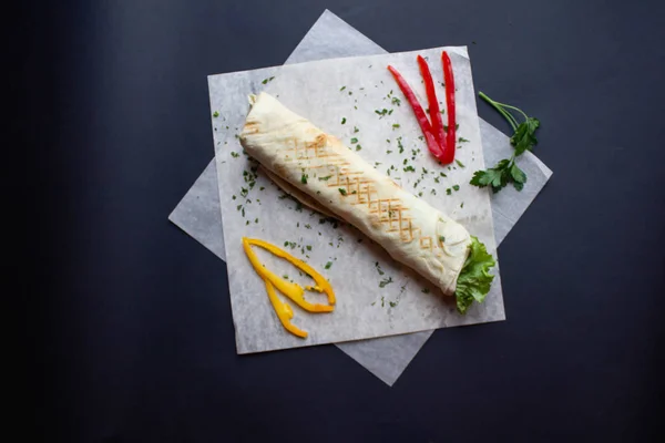 Koyu arka plan üzerinde malzemelerle Shawarma sandviç. Üstten görünüm. Pita ekmeği sandviç. börek