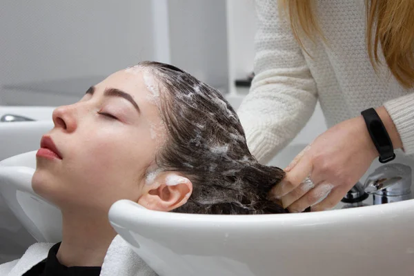 Uygulama şampuan ve saç bir müşterinin masaj kadın. Kadın onun saç güzellik salonunda yıkanmış olması.