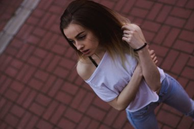 Sokak moda fotoğraf - şehirde yürüyen ve kamera poz genç güzel kadın portresi. Tonlu ve Filtreli Fotoğraf.