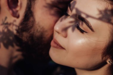 Aşık genç sevgi romantik çift kafa vurdu. Gözleri kapalı, birbirine yakın olan çekici esmer kız ve adam portresi kapatın. İlk öpücük, hassasiyet ve aşıklık kavramı