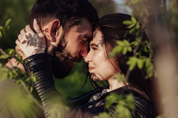 Aşık genç mutlu çift gün batımında birbirlerine sarılmak ve gülümseyerek